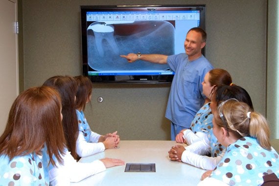 Dr. Harris presenting an x-ray to his staff in the conference room