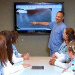 Dr. Harris presenting an x-ray to his staff in the conference room