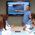 Dr. Harris presenting an x-ray to his staff in the conference room